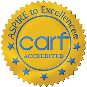 A gold seal with blue text reads ASPIRE to Excellence® CARF ACCREDITED, surrounded by blue stars.