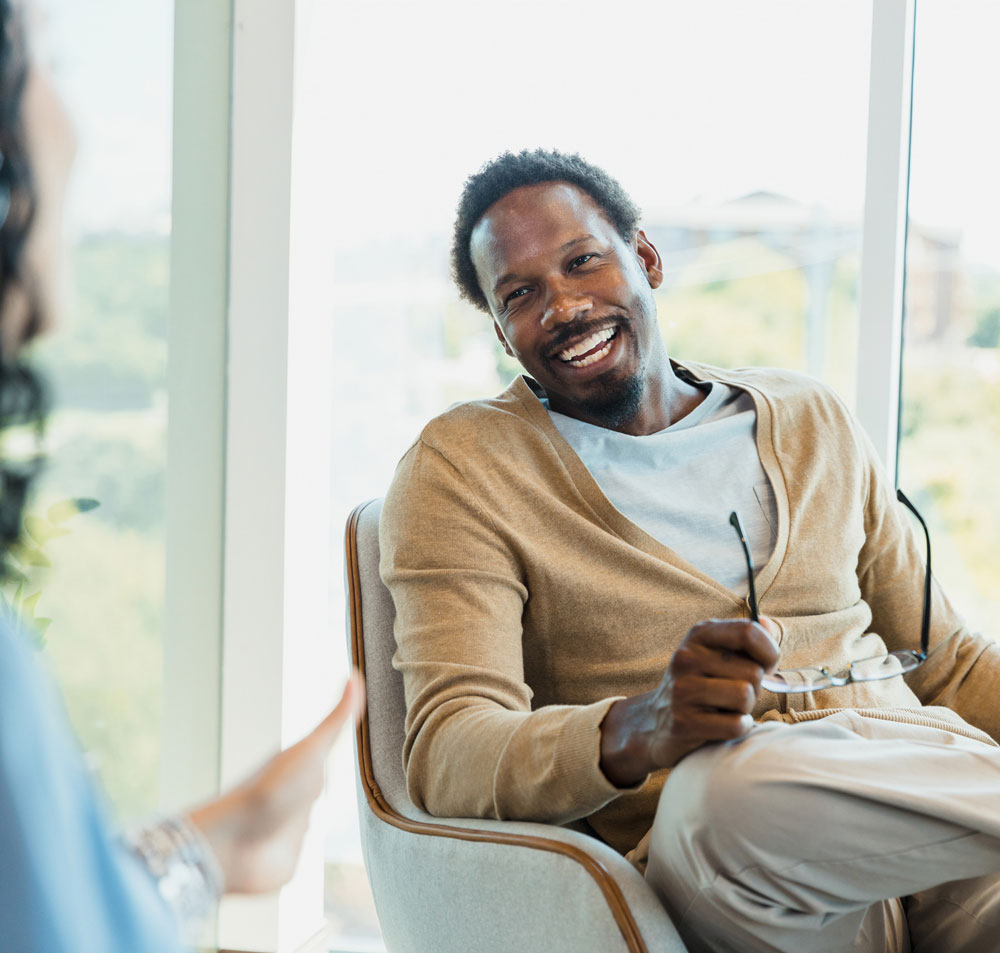 Therapist talking with a client - happy man in counseling - recovery center